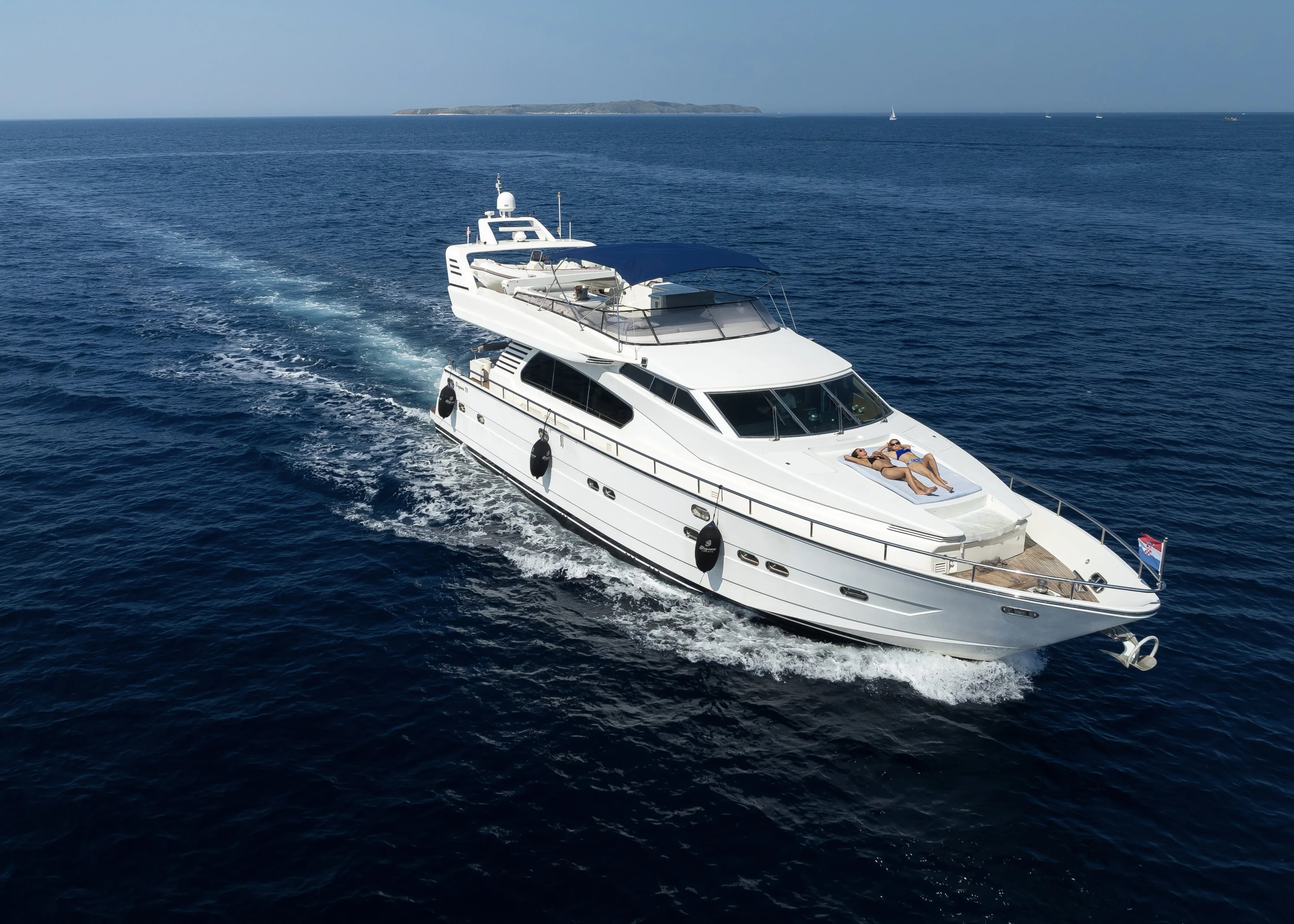 The yacht under way, guests stretched out on the foredeck